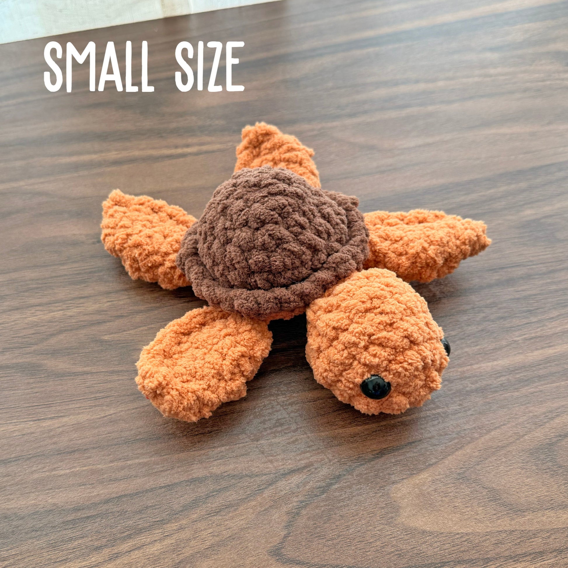 Small turtle plush with a brown shell and burnt orange body 